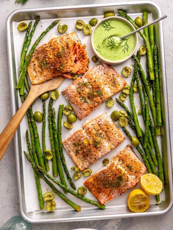 Overhead shot of sheet pan salmon and asparagus bowls on a styled dinner table