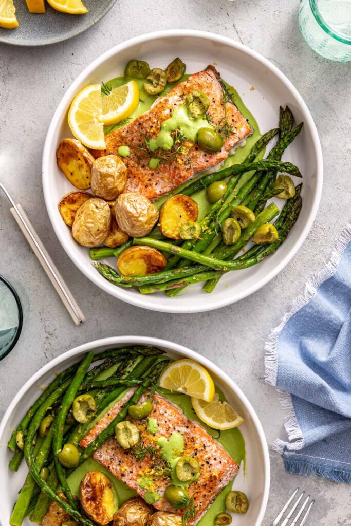 Salmon and asparagus plated with potatoes and fresh herbs
