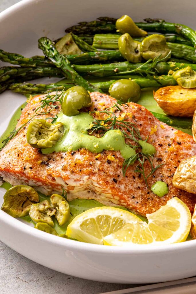 Side view of baked salmon fillet with asparagus and roasted potatoes