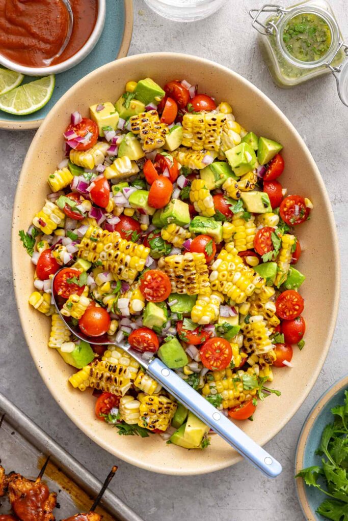 Charred corn salad with avocado and tomatoes served family style