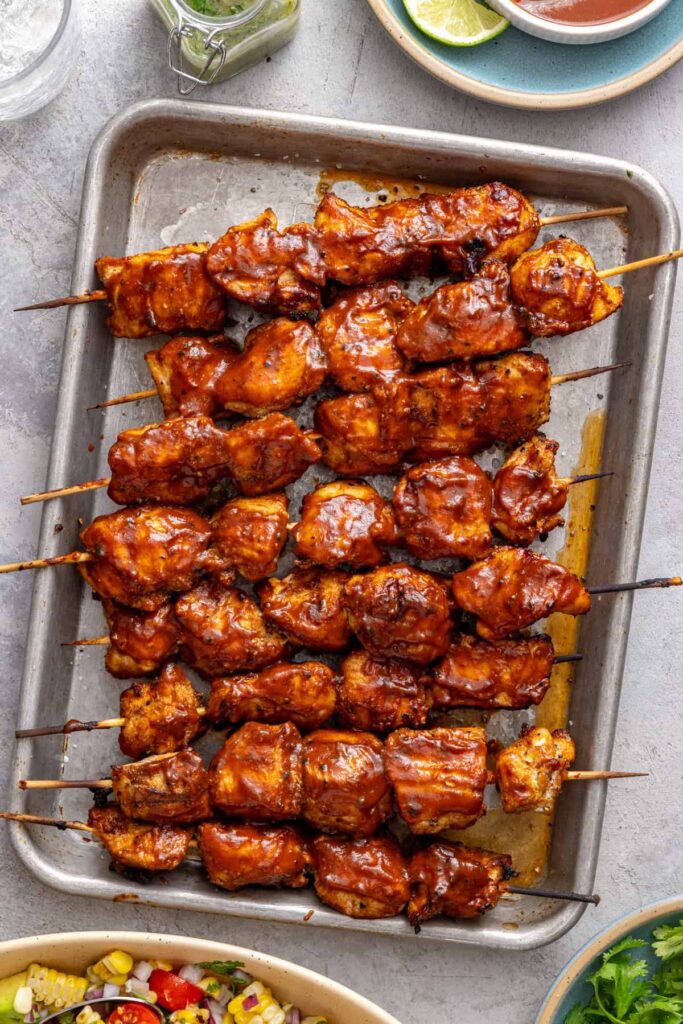 Overhead view of healthy BBQ chicken skewers on a sheet pan