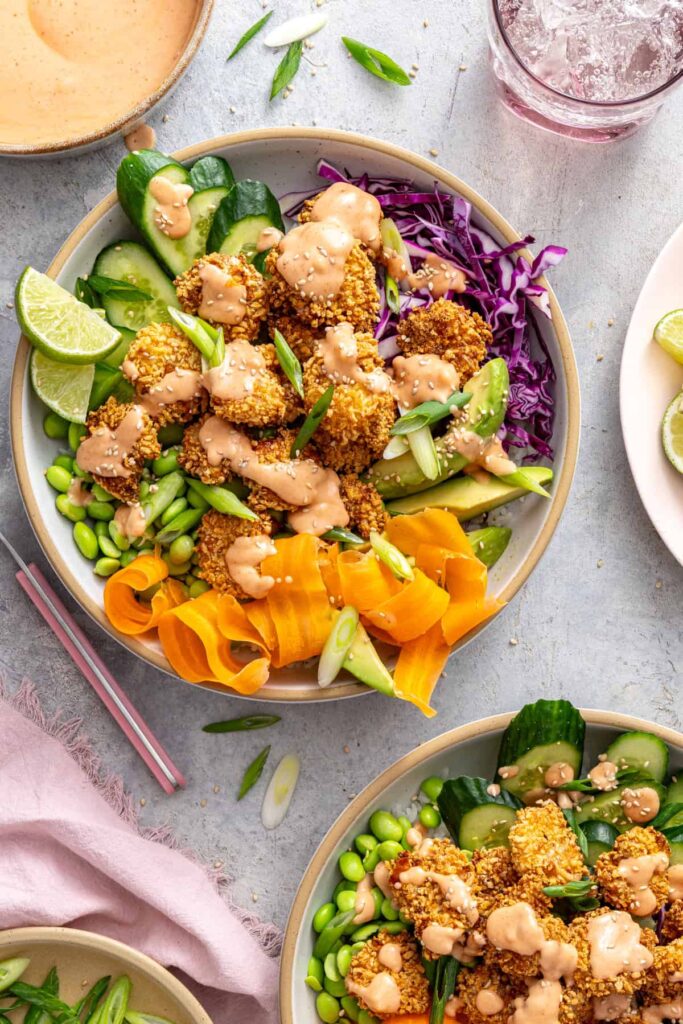 healthy air fryer bang bang shrimp bowls with colorful vegetables on a set table