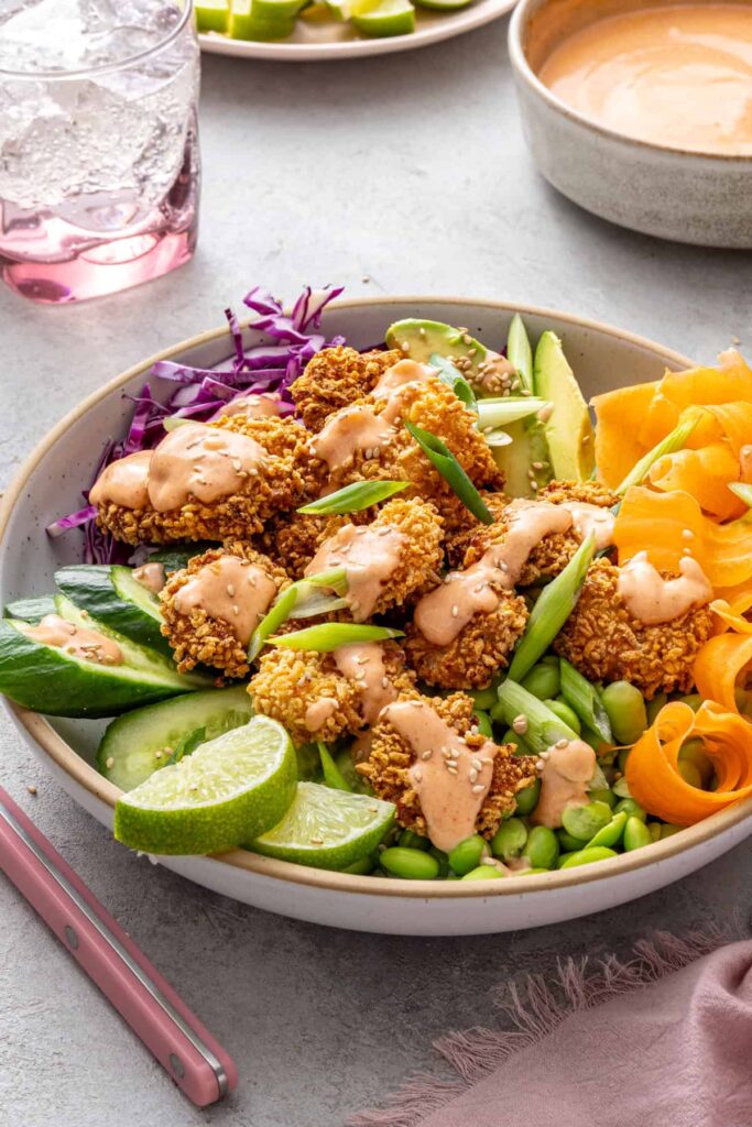 Healthy bang bang shrimp bowl topped with creamy sweet and spicy sauce.