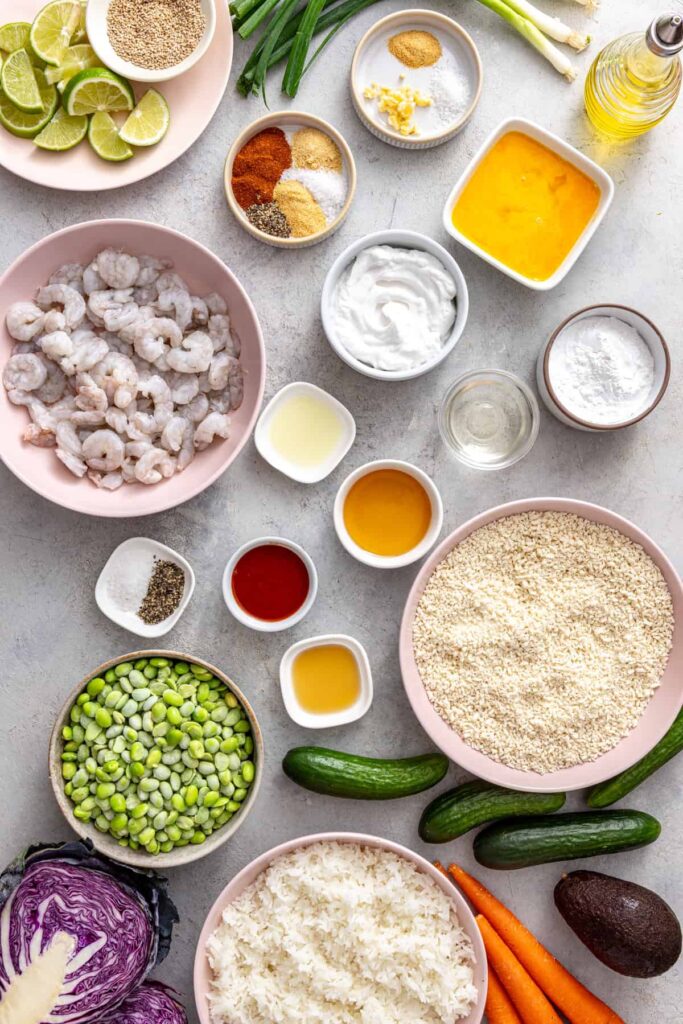 Healthy air fryer bang bang shrimp ingredients including shrimp, gluten-free panko, coconut yogurt, vegetables, rice and seasonings.
