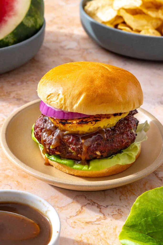 Side view of juicy Hawaiian teriyaki burger with grilled pineapple