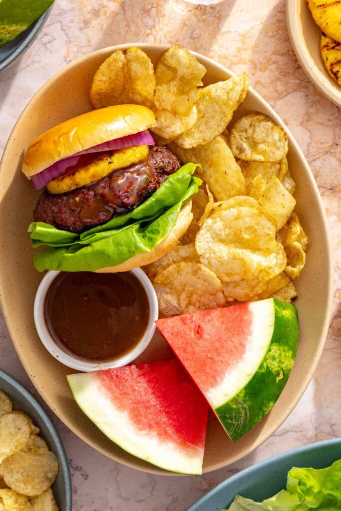 Homemade Hawaiian burger served with watermelon and potato chips