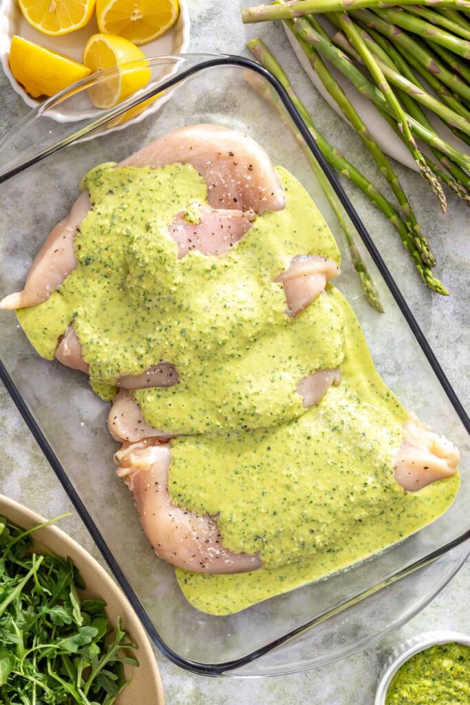 Chicken breasts coated in lemon pesto marinade before grilling