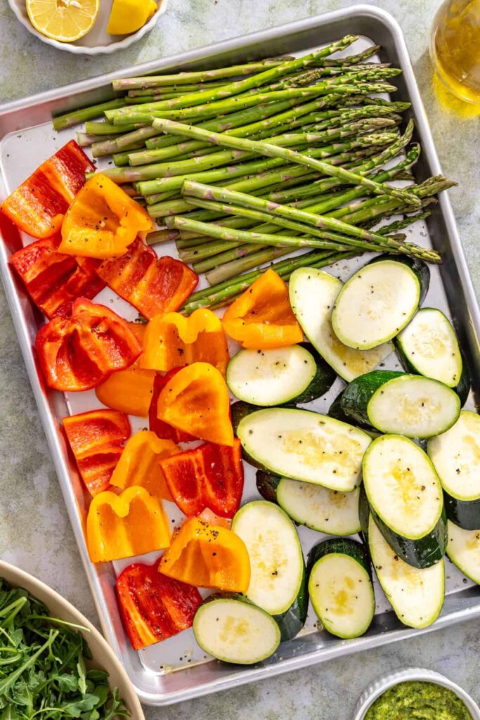 Zucchini, asparagus, and bell peppers tossed with olive oil before grilling
