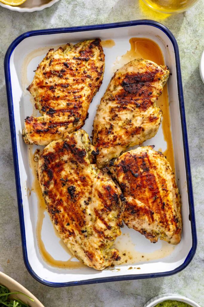 Overhead view of lemon pesto grilled chicken resting after grilling