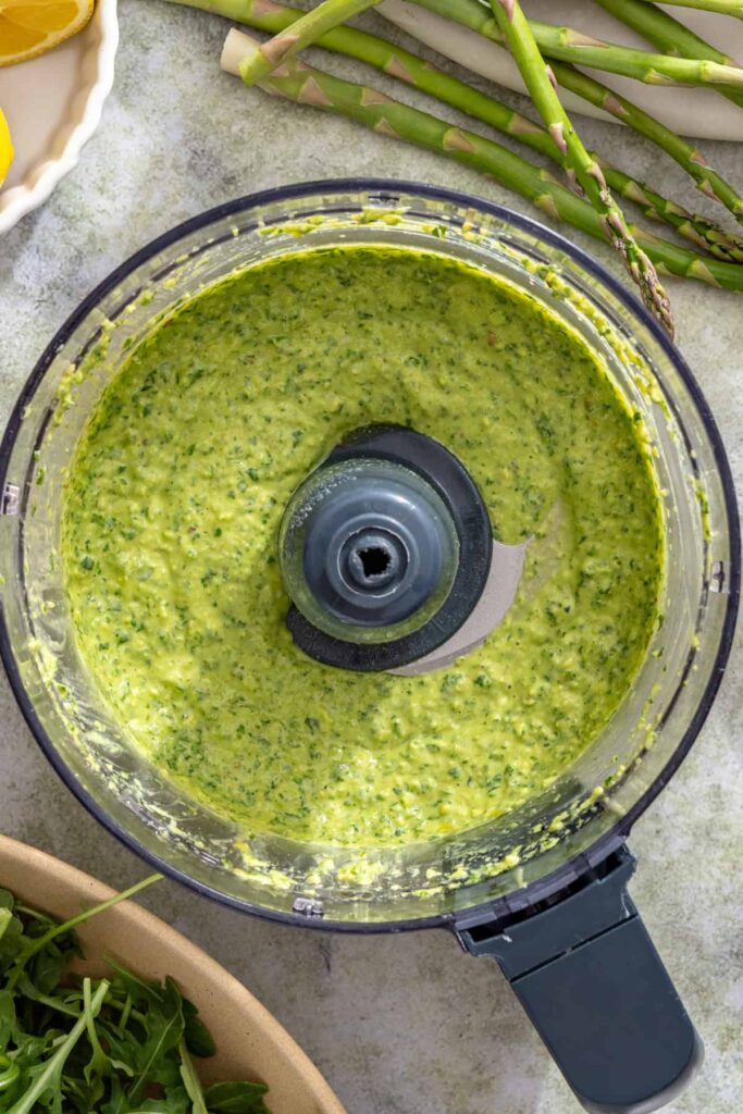 Fresh lemon basil pesto being blended until smooth and textured
