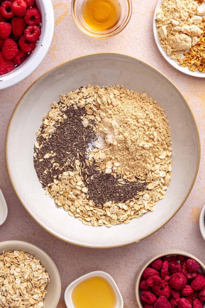 Rolled oats, PB2, chia seeds, and sea salt in a bowl, ready to be mixed for overnight oats