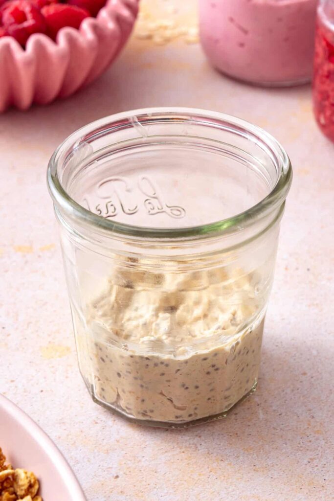 Building layers of overnight oats and homemade raspberry jam