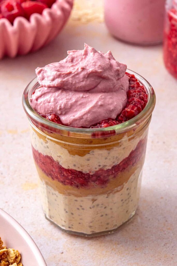 Peanut butter and jelly overnight oats topped with raspberry Greek yogurt whip
