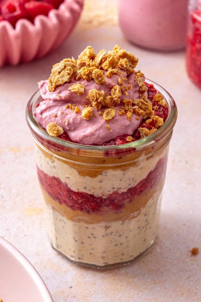 Peanut butter and jelly overnight oats topped with raspberry yogurt whip and peanut butter oat crumble