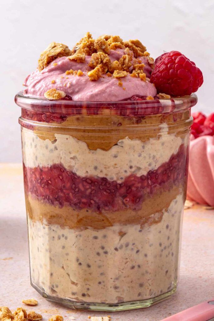 gluten-free Peanut butter overnight oats with raspberry topping served for breakfast