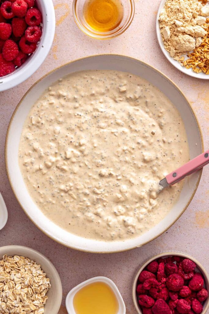 Mixing Greek yogurt, peanut butter, oats, and almond milk for overnight oats