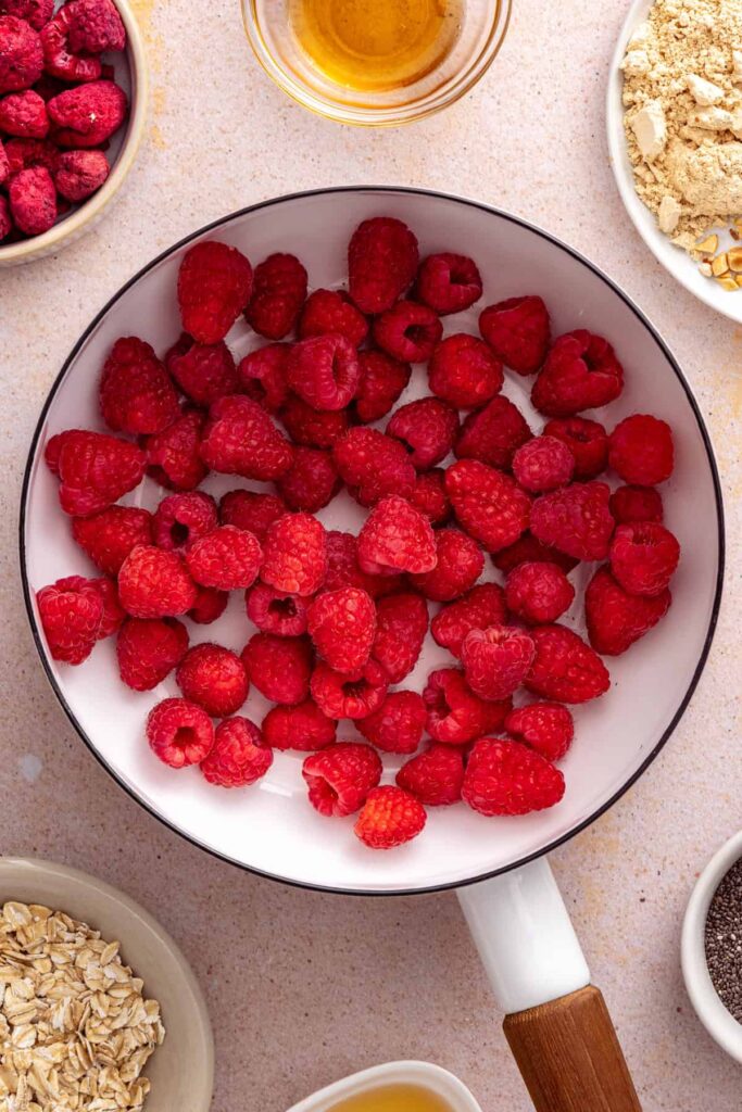 Fresh raspberries cooking in a saucepan for homemade raspberry chia jam