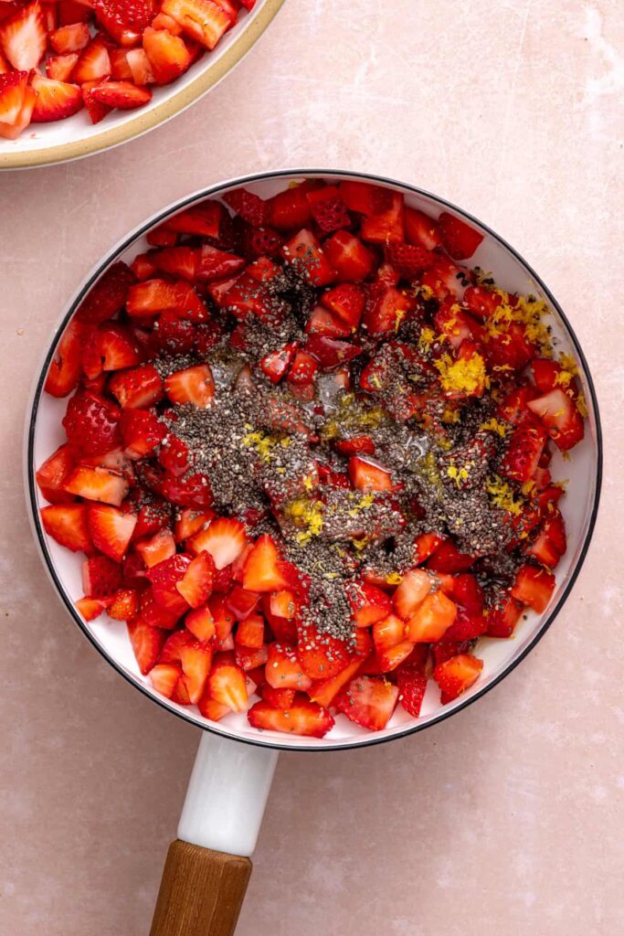 Simmering strawberries with chia seeds and maple syrup for strawberry oatmeal bars.