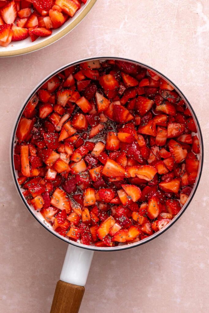 Cooking fresh strawberries into a homemade strawberry chia jam filling.