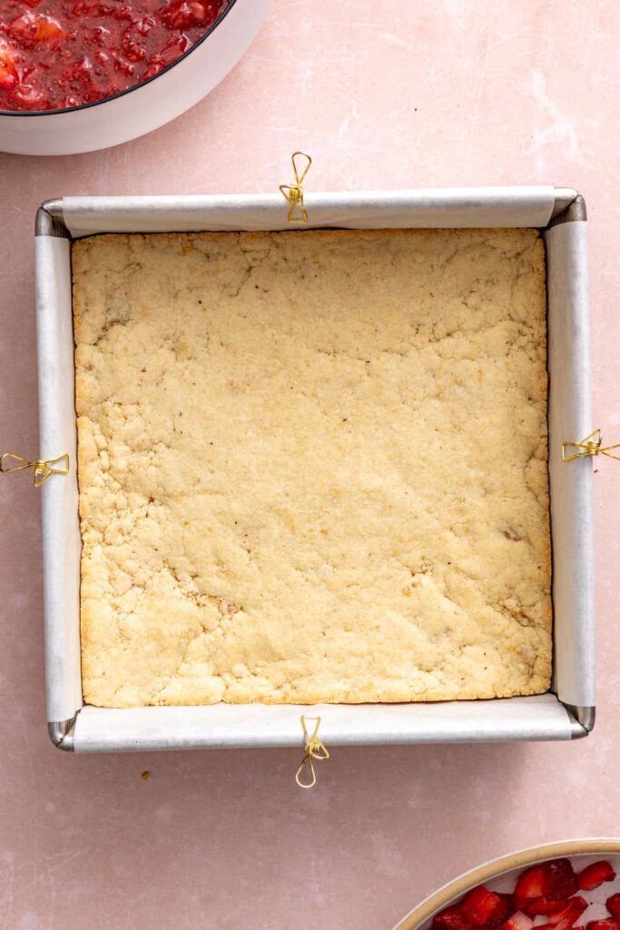 Lightly baked shortbread crust for homemade strawberry oatmeal bars.
