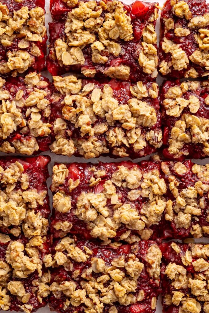 Close-up of sliced strawberry oatmeal bars with a buttery oat crumble topping.