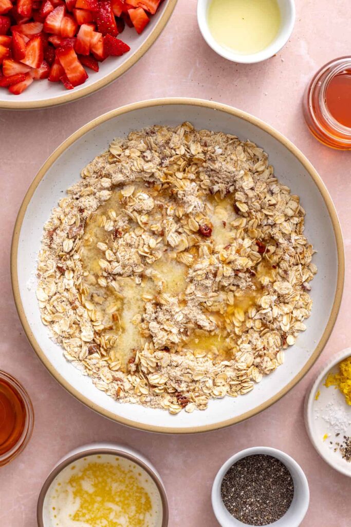 Forming buttery oat crumble clusters for gluten-free strawberry oatmeal bars.
