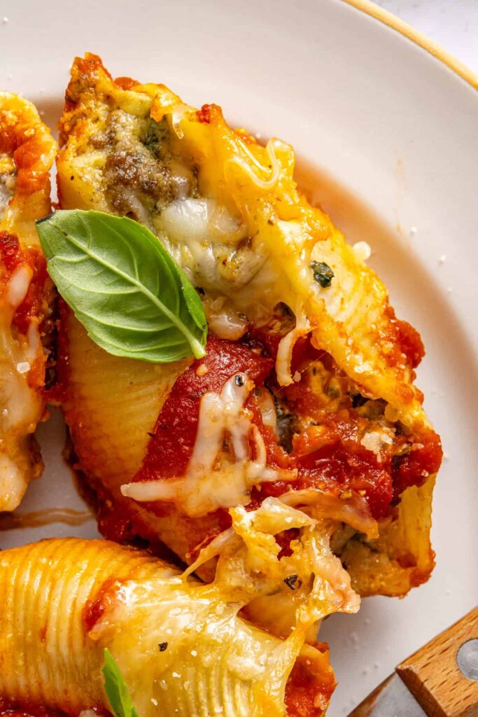 Close-up of plated stuffed shells showing creamy ricotta filling and marinara-coated pasta