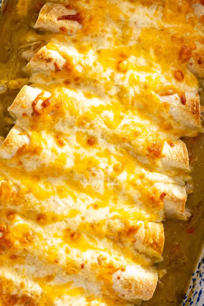close-up of Golden baked chicken enchiladas with salsa verde fresh from the oven