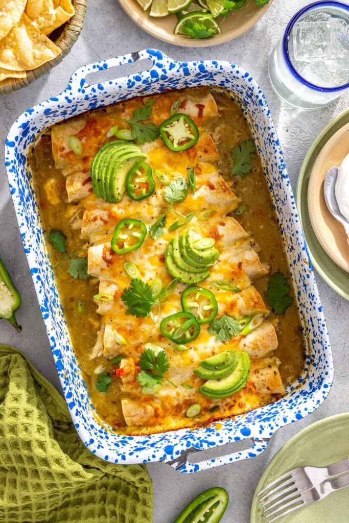 Finished chicken enchiladas with salsa verde topped with fresh herbs