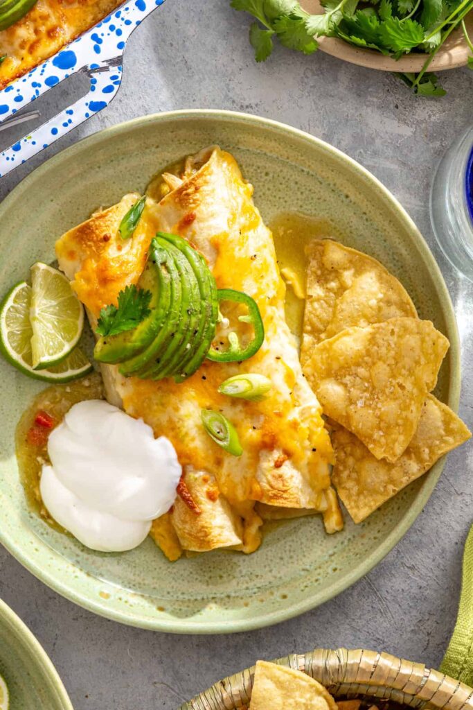 overhead view of creamy green chicken enchiladas with salsa verde served on a plate