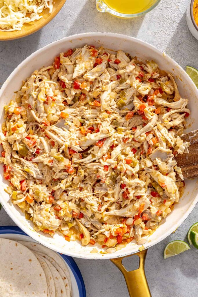 Chicken enchilada filling combined in a skillet before rolling