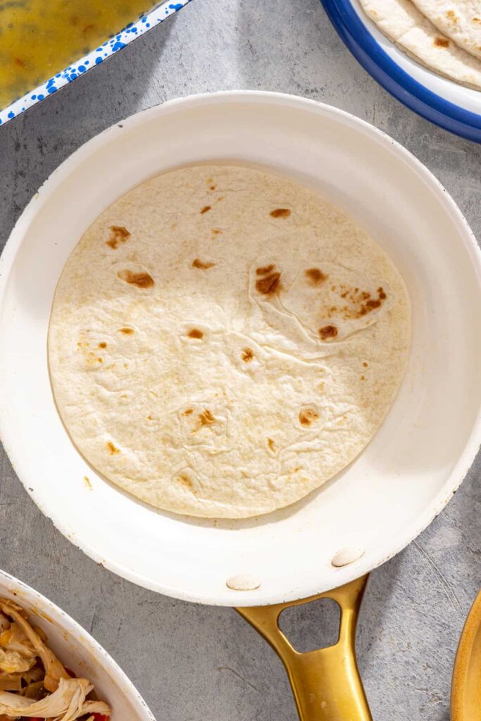 Warm tortillas prepared for rolling creamy chicken enchiladas