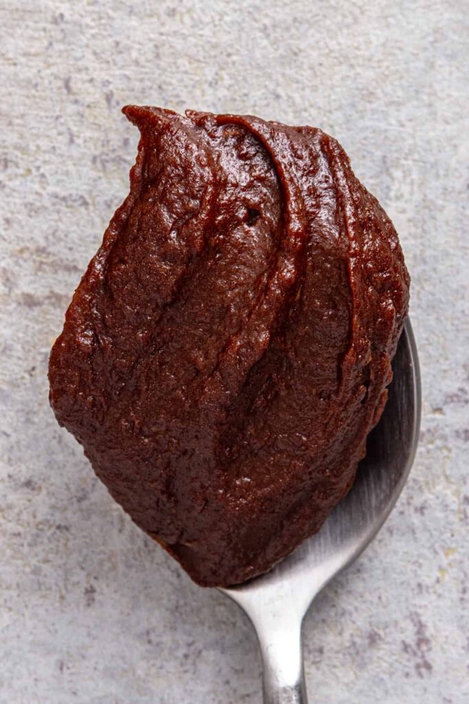 Thick homemade healthy chocolate frosting on a spoon