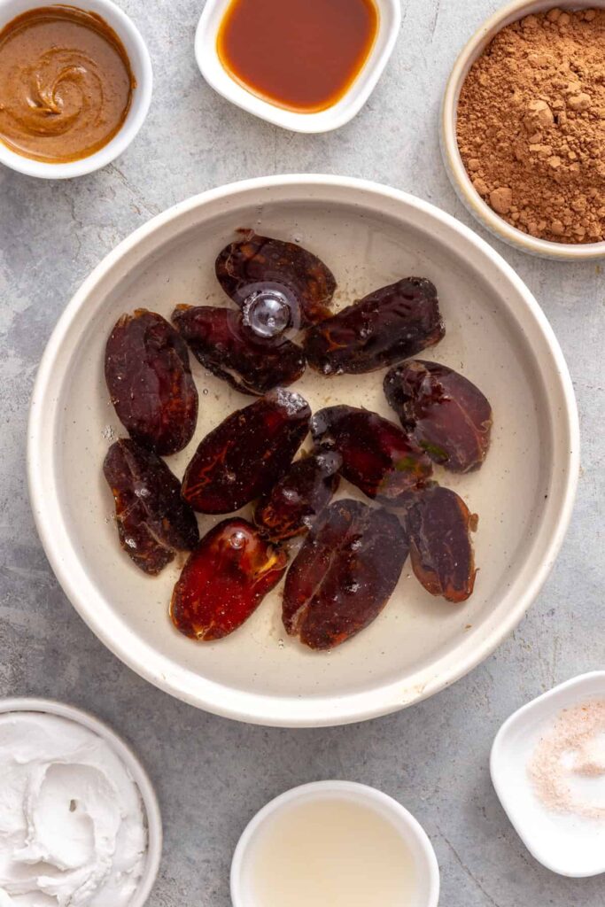Medjool dates soaking in hot water to soften before making healthy chocolate frosting.