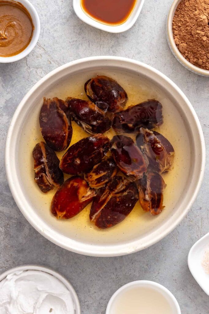 Pitted Medjool dates soaking before blending into chocolate frosting