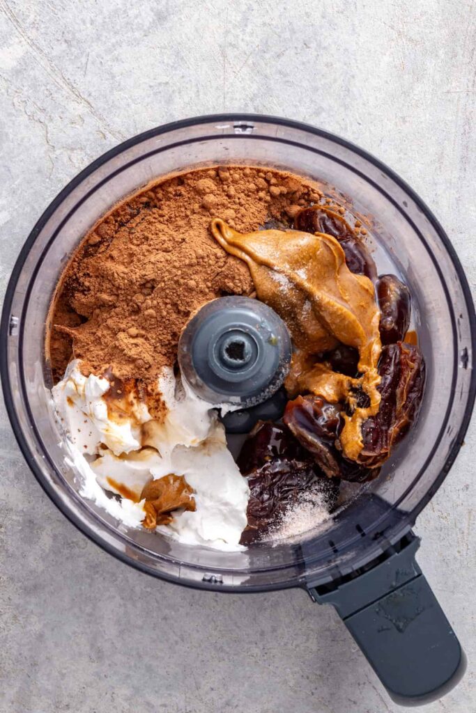 Dates, cacao powder, coconut cream, almond butter, vanilla, and sea salt in a food processor