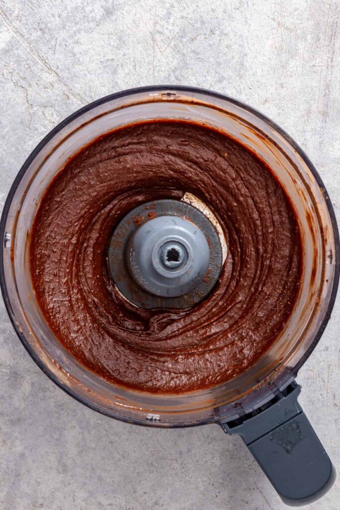 Freshly blended healthy chocolate frosting in a food processor before chilling