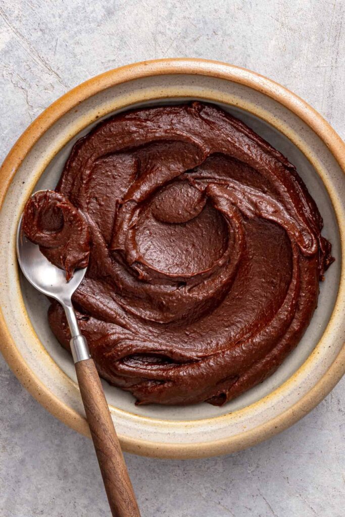 Healthy chocolate frosting served in a bowl with a smooth, creamy texture