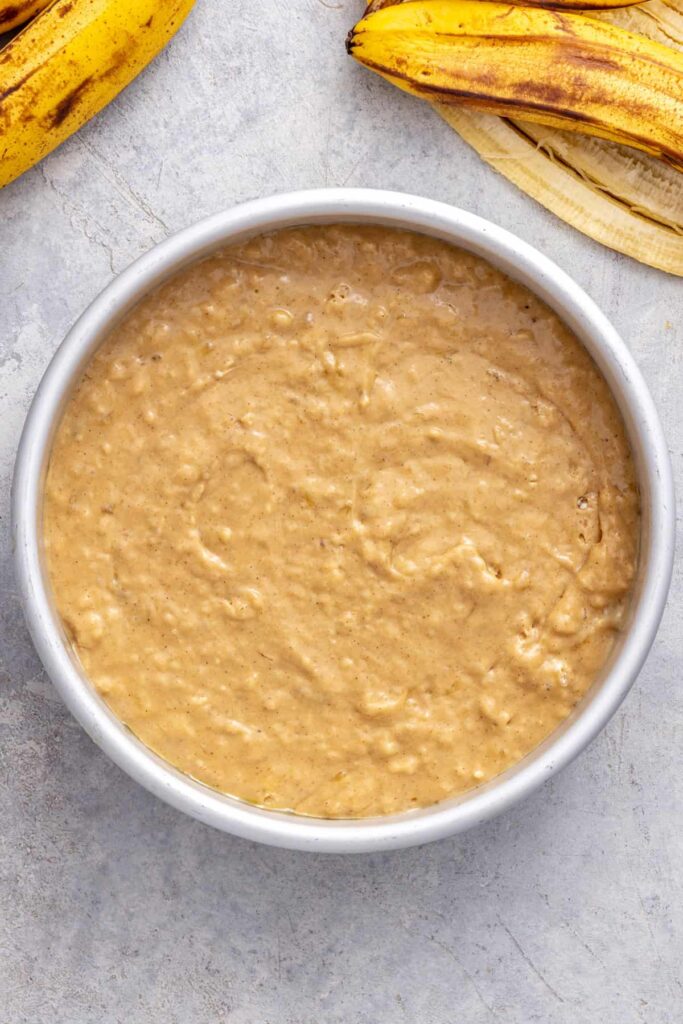 Healthy banana birthday cake batter spread evenly in prepared cake pan