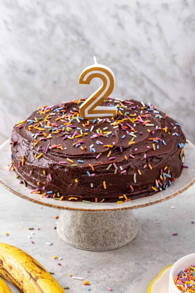 Healthy birthday cake for kids decorated with rainbow sprinkles and a number 2 candle