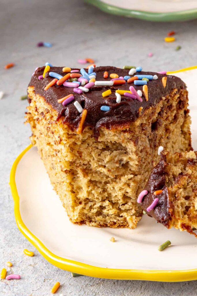 Soft and fluffy healthy banana birthday cake slice with a bite taken out to show texture