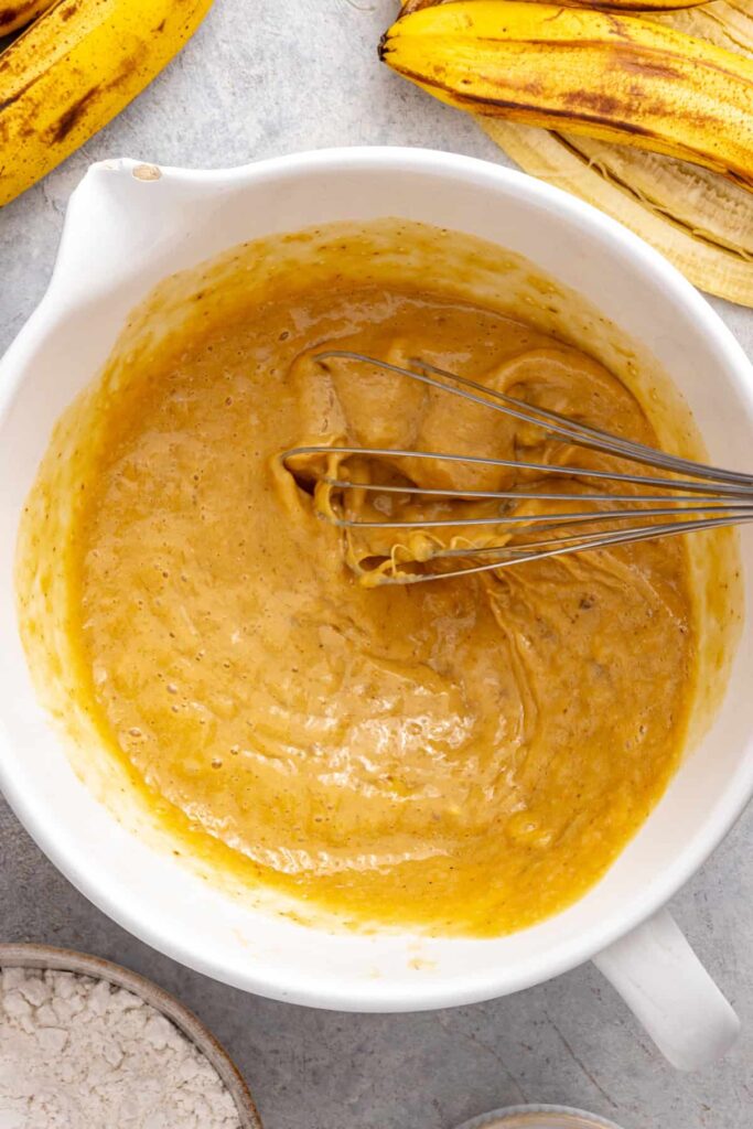 whisking mashed bananas, eggs and Greek yogurt for banana birthday cake