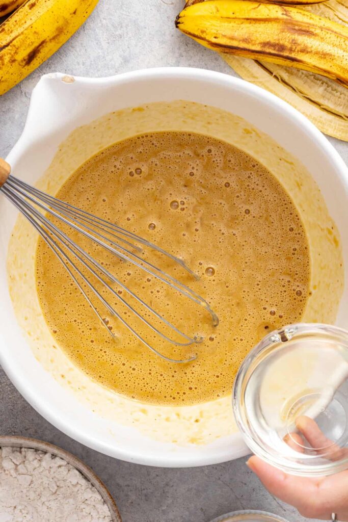 Wet ingredients being whisked together for healthy banana birthday cake batter