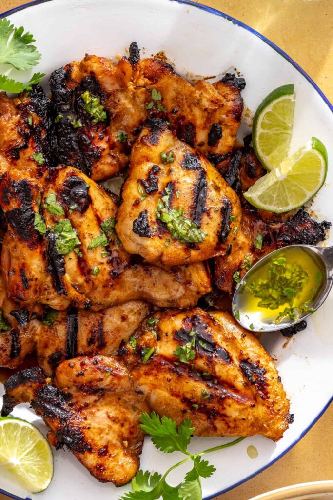 Drizzling cilantro-lime sauce over honey lime grilled chicken