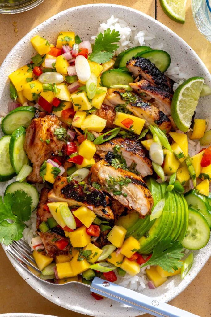 close-up of honey lime grilled chicken with mango salsa and cilantro-lime drizzle