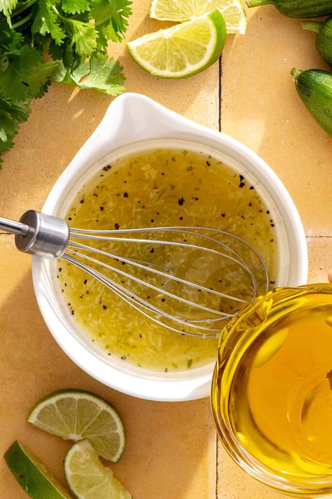 Slowly whisking olive oil into cilantro-lime drizzle