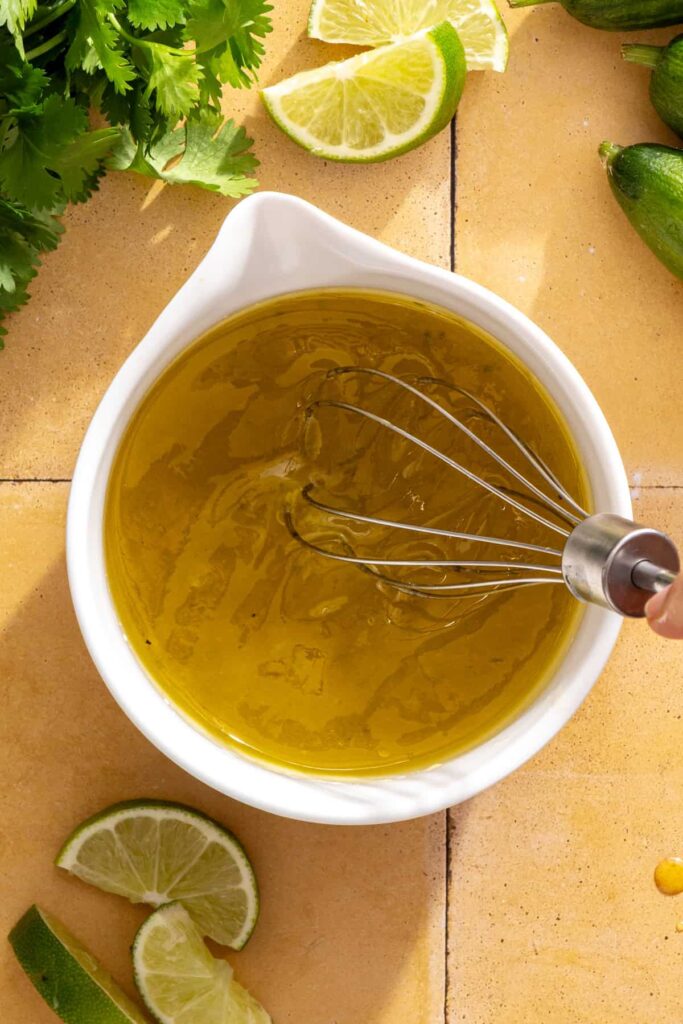 Whisking cilantro-lime drizzle with honey, lime juice, garlic, and olive oil