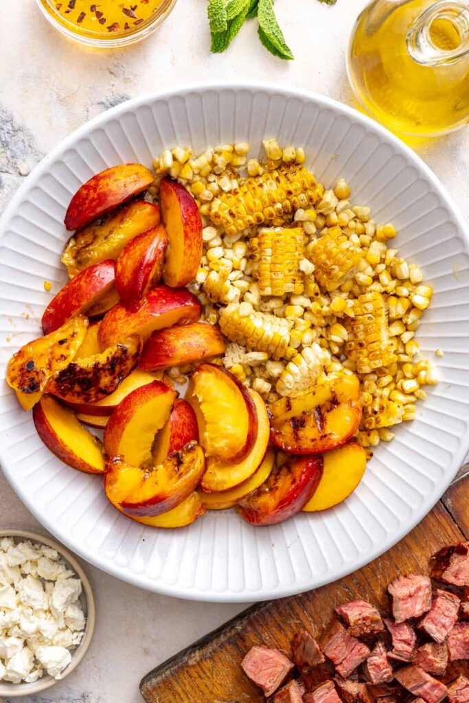 Chopped charred peaches and grilled corn in a bowl