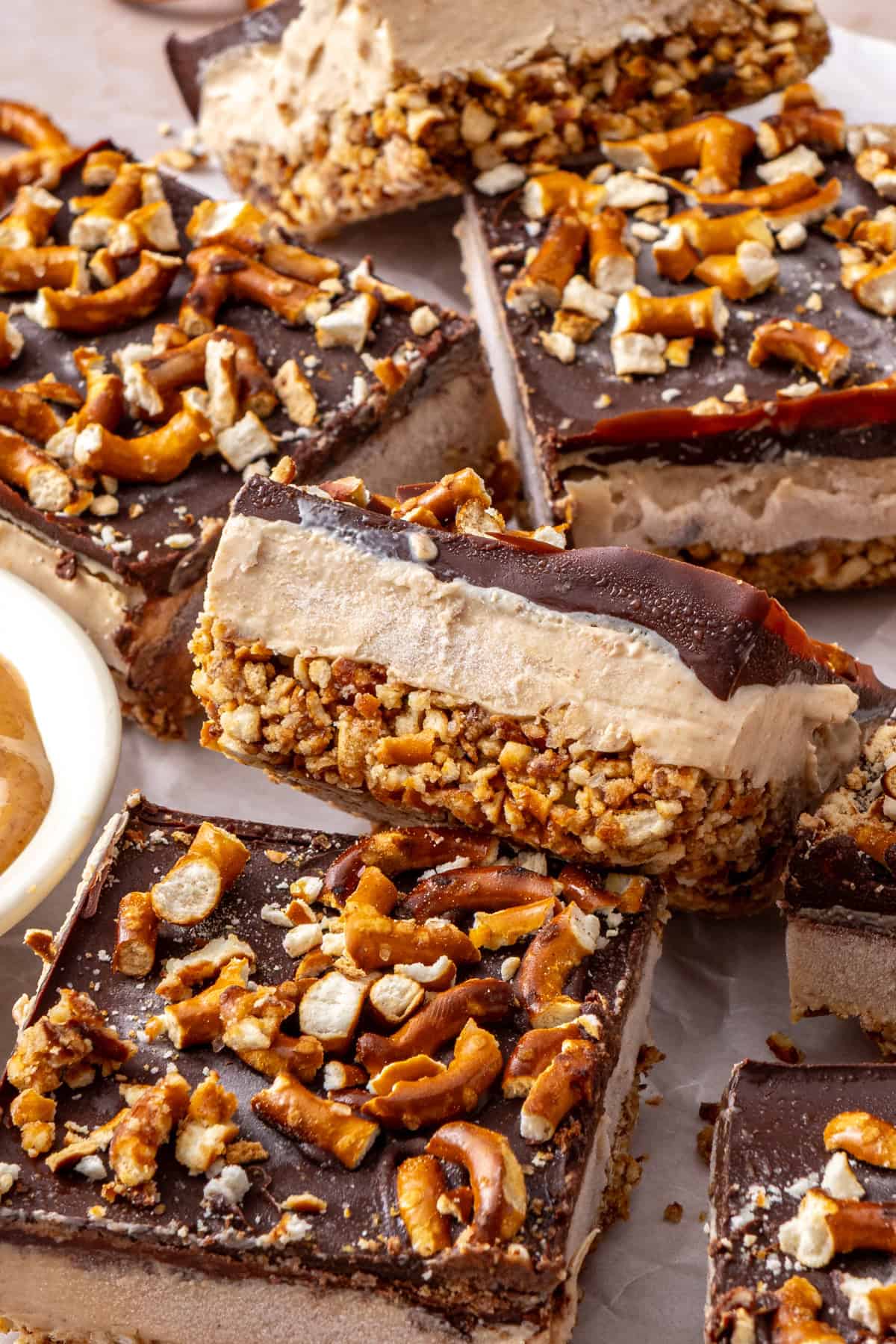 Close-up of Frozen Peanut Butter Pretzel Bars showing the creamy peanut butter protein filling, crunchy pretzel crust, and dark chocolate topping.