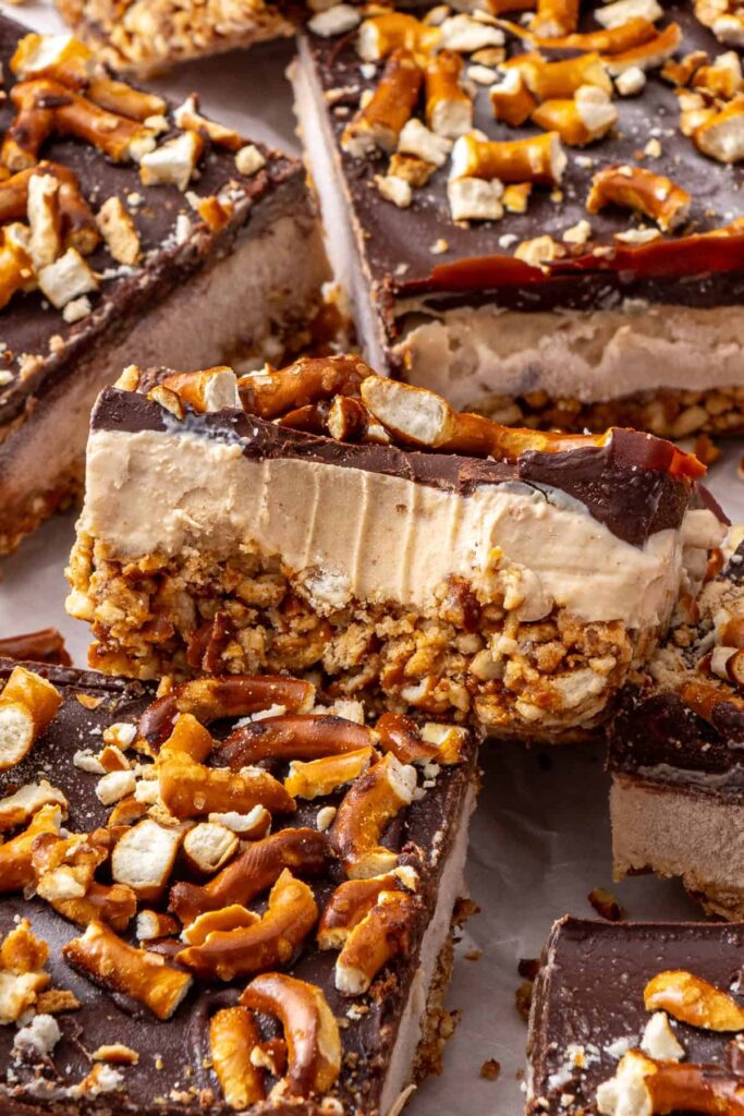 Individual frozen peanut butter pretzel dessert bar with a bite taken out, showing the texture
